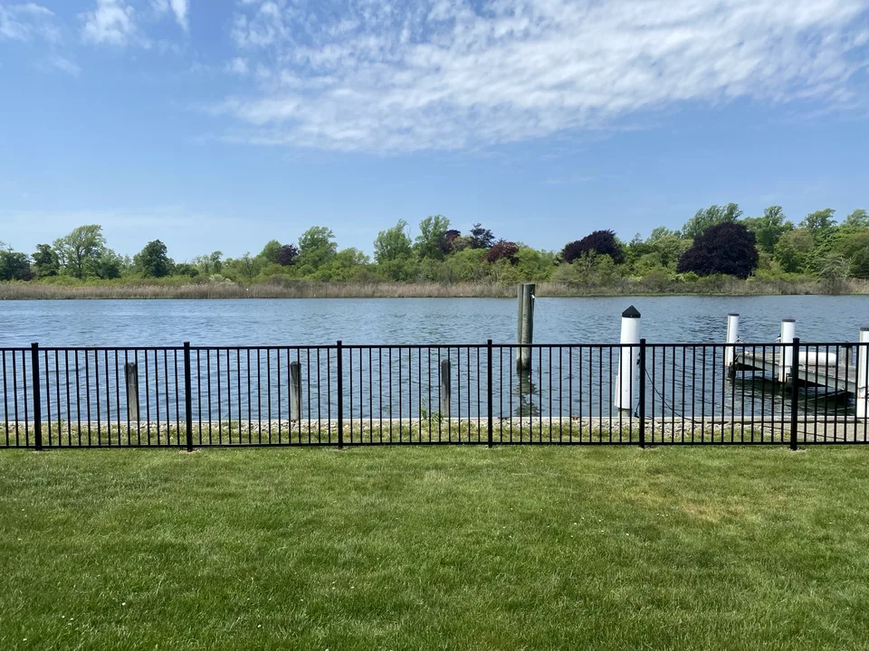 Four-foot black aluminum fence along a waterfront bulkhead in East Islip, New York.