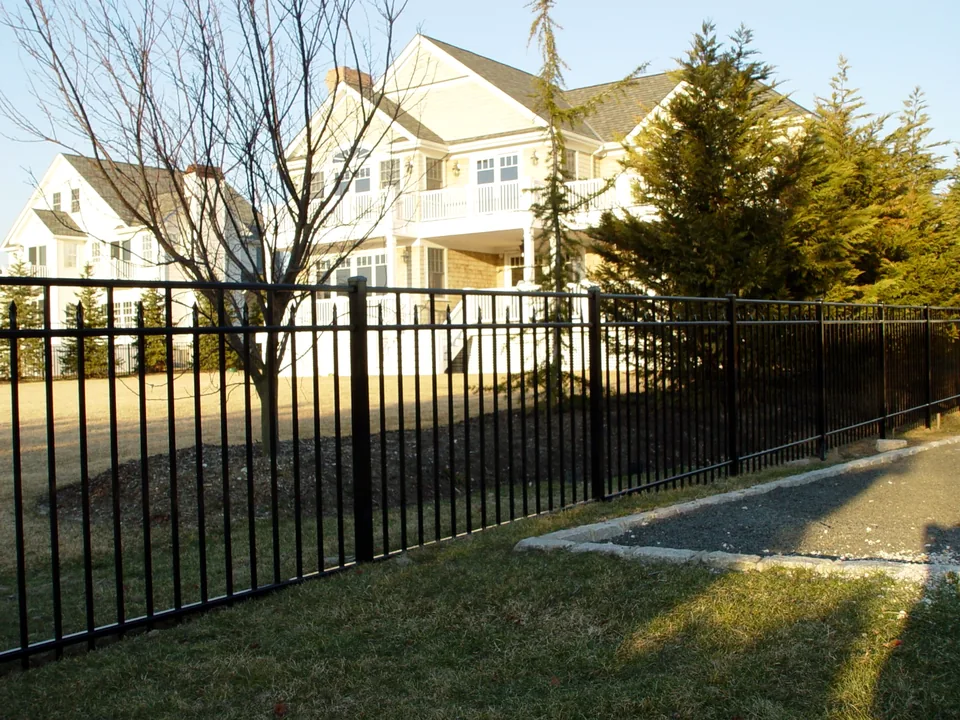 Four-foot black aluminum fence extending along a residential property line in Center Moriches, New York.