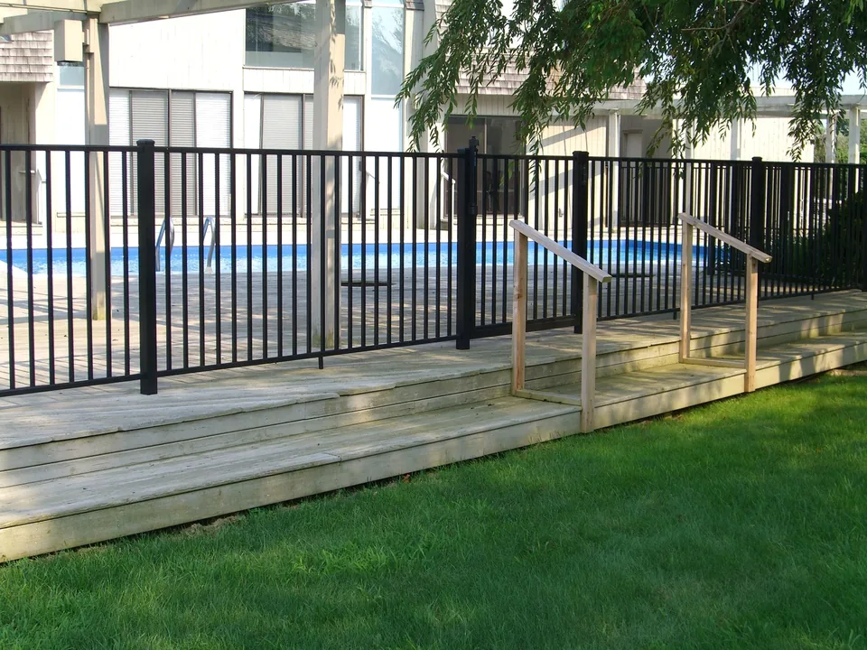 Four-foot black aluminum fence following the edge of a raised wood deck in Southampton, New York.