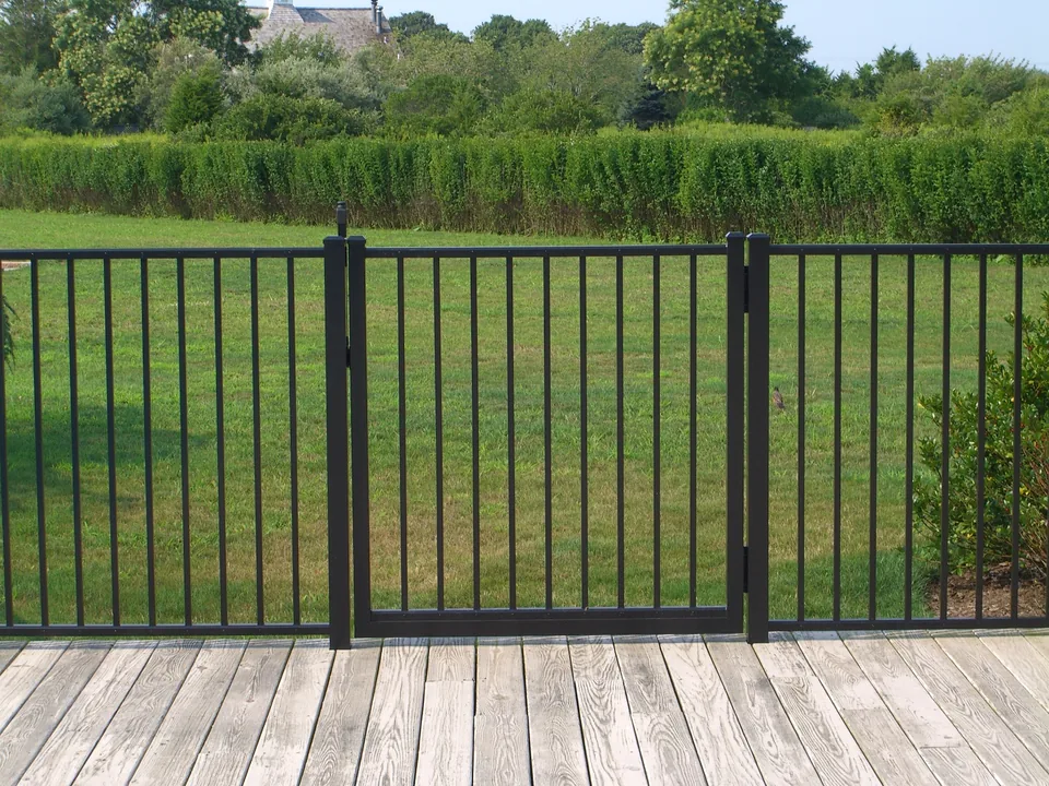Black aluminum walk gate within a four-foot fence installed on a wood deck in Southampton, New York.