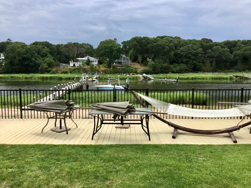 Wide backyard view of a four-foot black aluminum perimeter fence in Mattituck, New York.