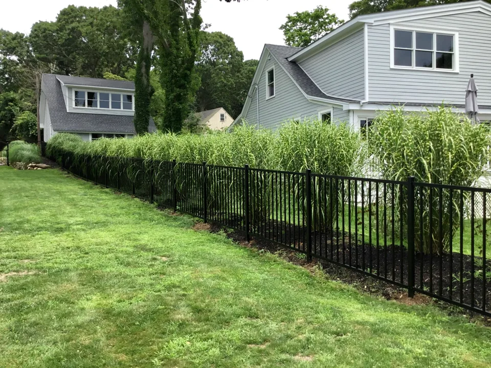 Four-foot black aluminum backyard perimeter fence extending across a Mattituck, New York property.