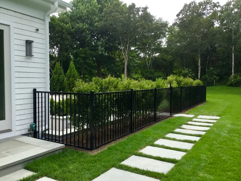 Four-foot black aluminum fence following a residential property perimeter in Southampton, New York.