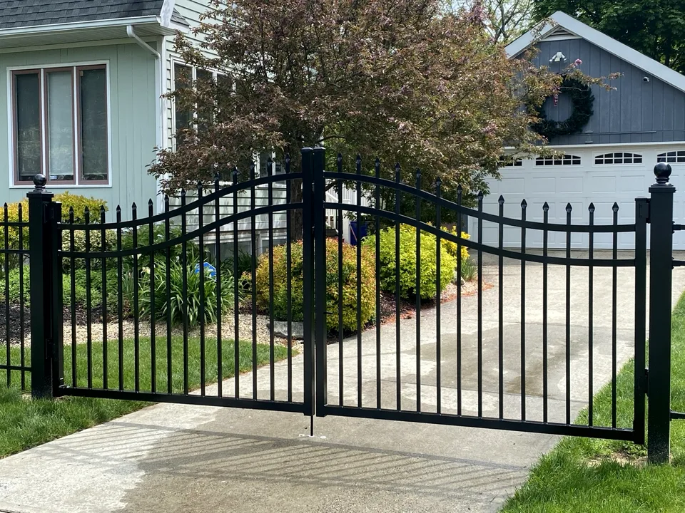 Arched black aluminum double-drive gates with spear-point pickets in Mastic Beach, New York.