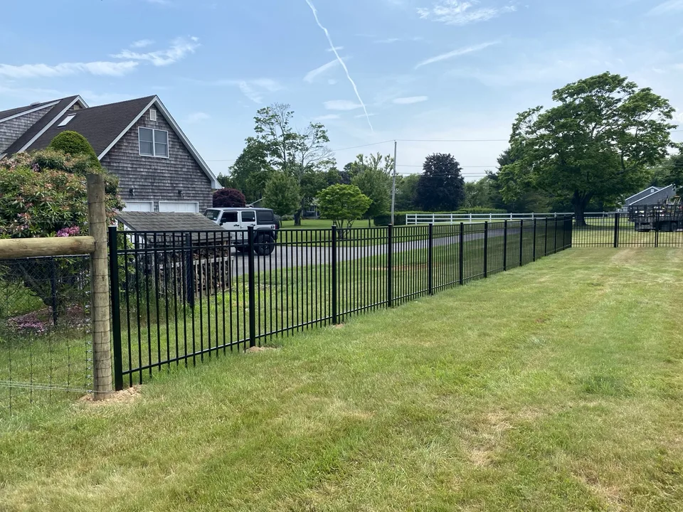 Five-foot black Style 202 aluminum fence extending along a large Center Moriches, New York property.