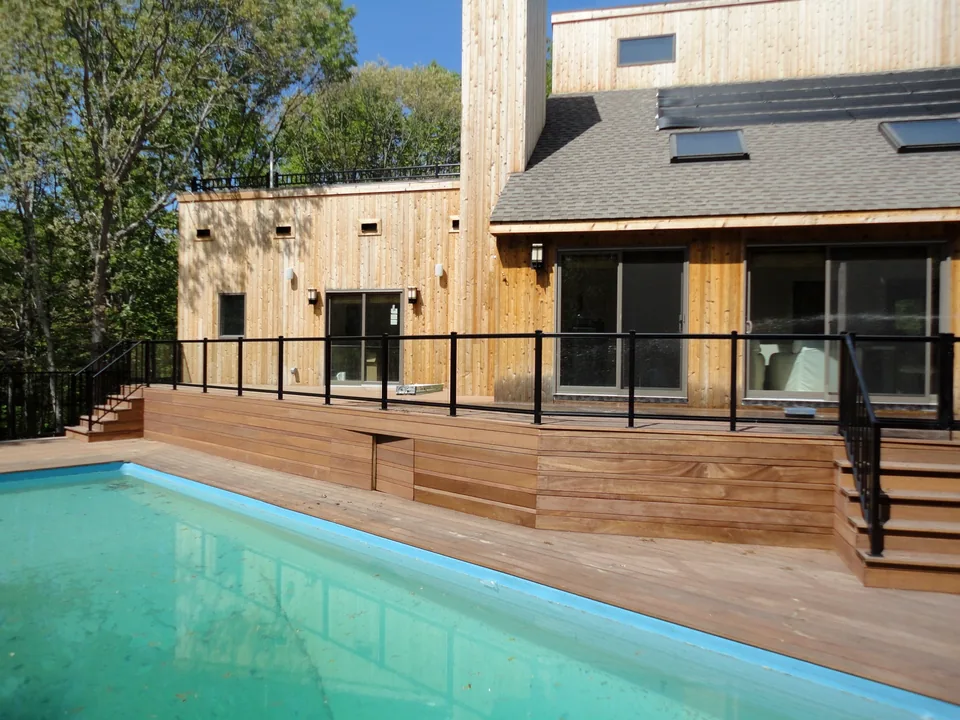 Aluminum-framed glass railing on an elevated wood pool deck in Southampton, New York