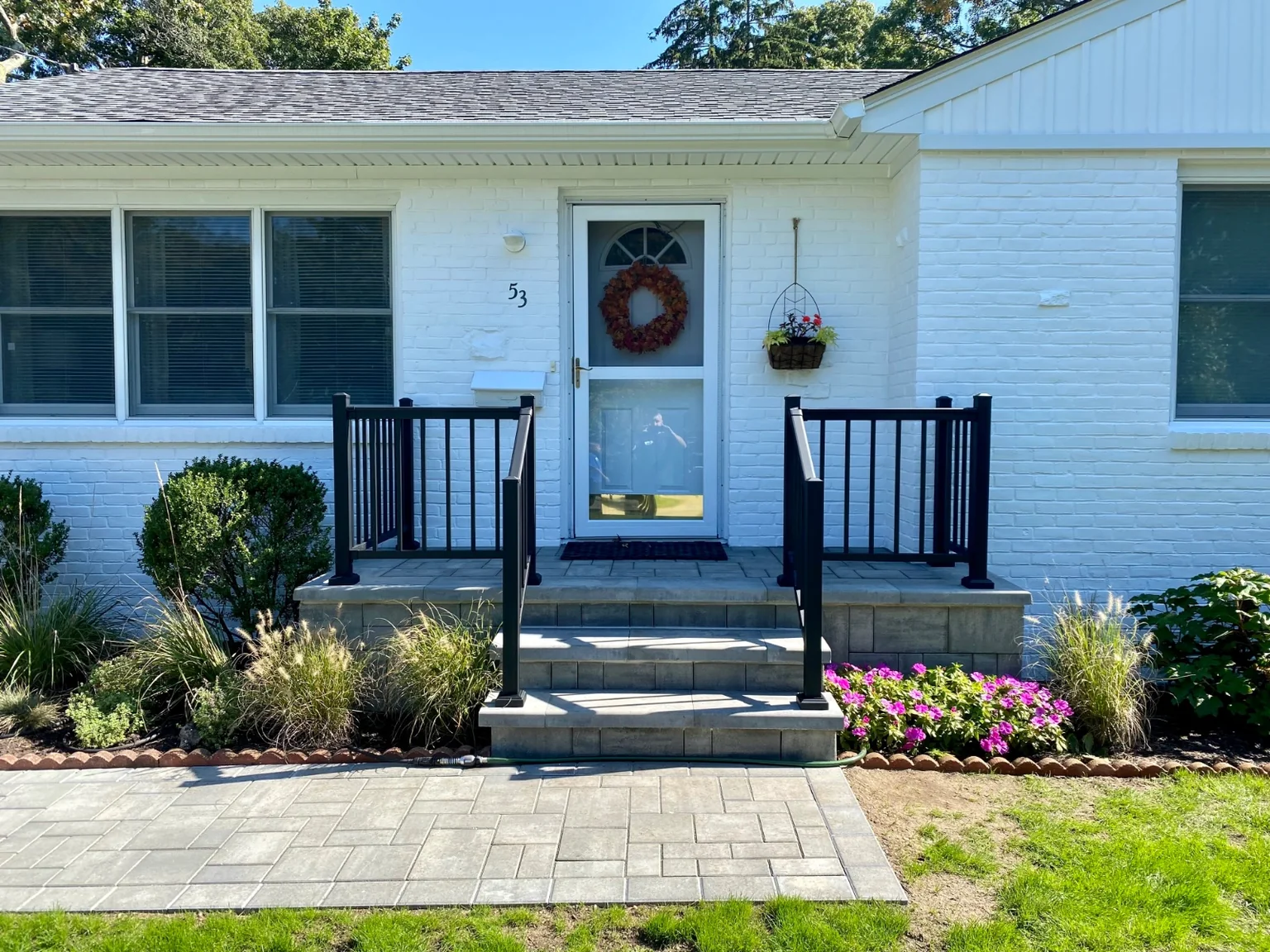 Black aluminum railing at the front stoop or backyard patio of a Bellport home