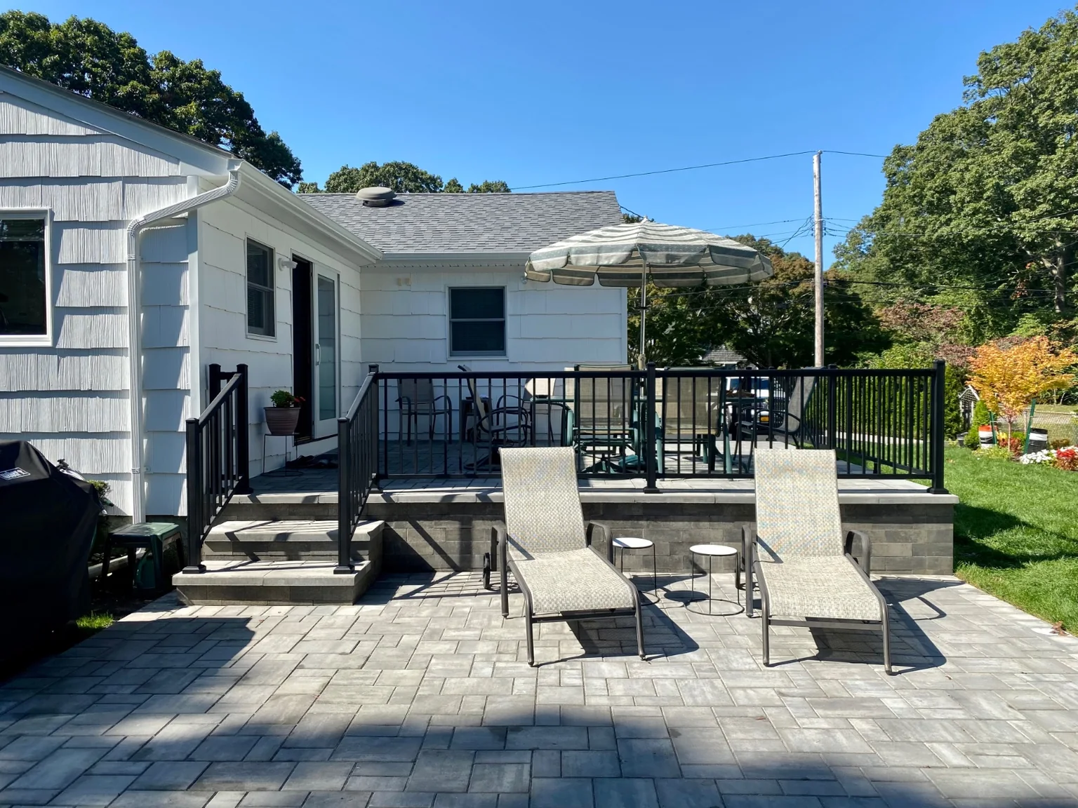 Black aluminum railing at the front stoop or backyard patio of a Bellport home