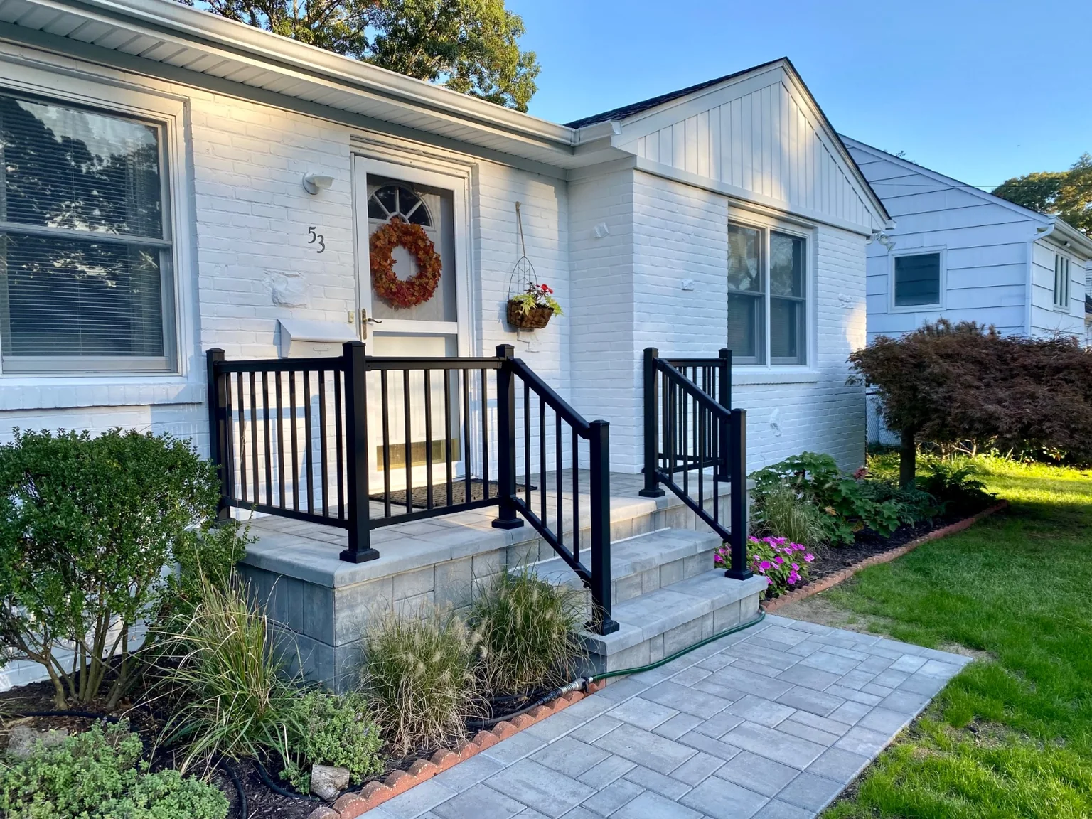 Black aluminum railing at the front stoop or backyard patio of a Bellport home
