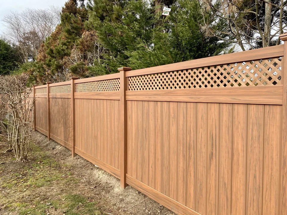 Long run of Cedargrain PVC privacy fence with lattice top in West Islip, New York