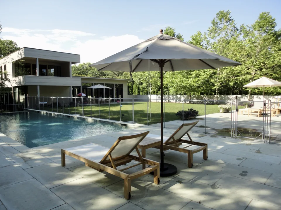 Guardian removable mesh pool fence surrounding a modern East Hampton pool