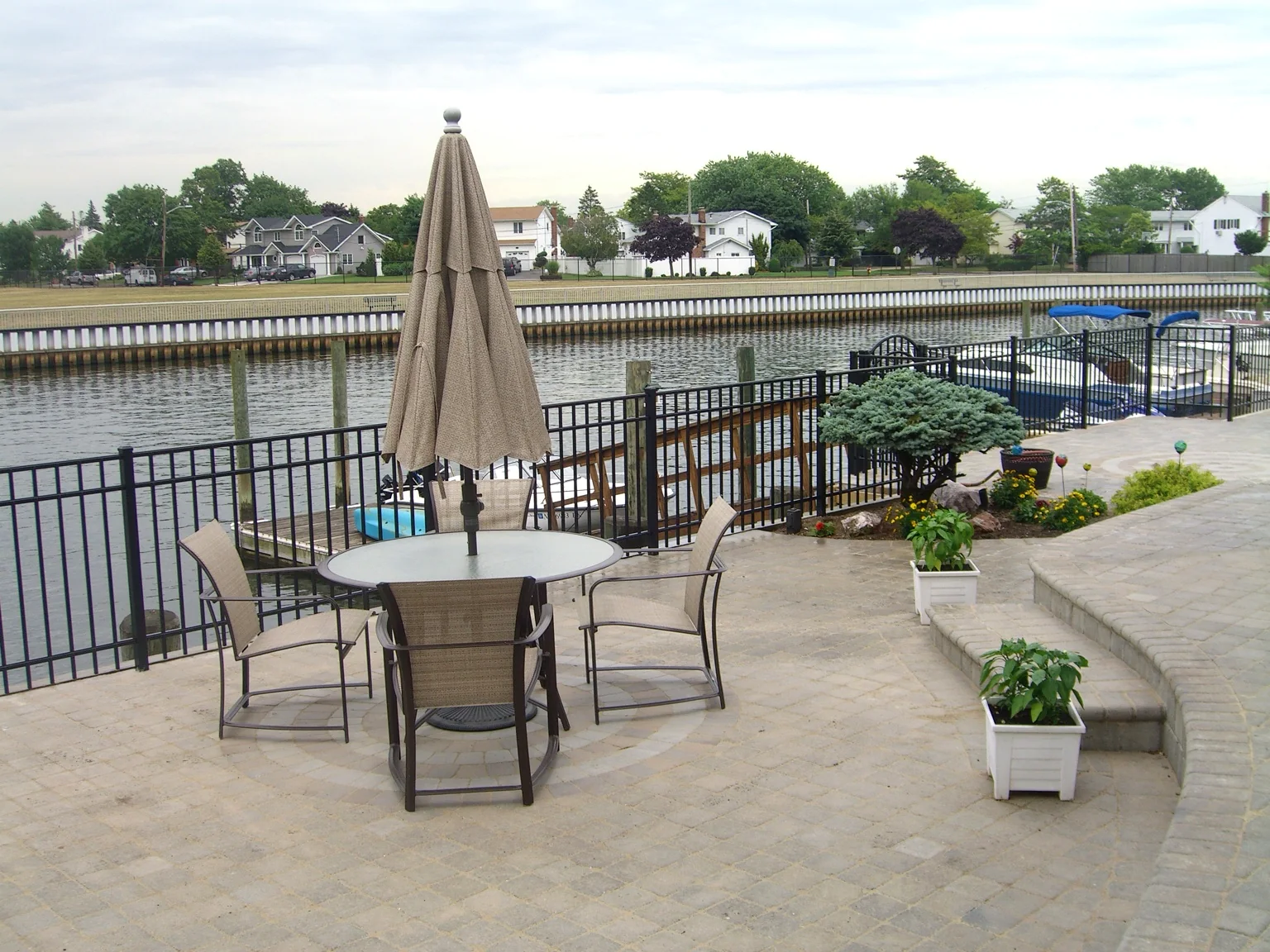 Black aluminum fence along a raised masonry waterfront patio in Seaford, New York