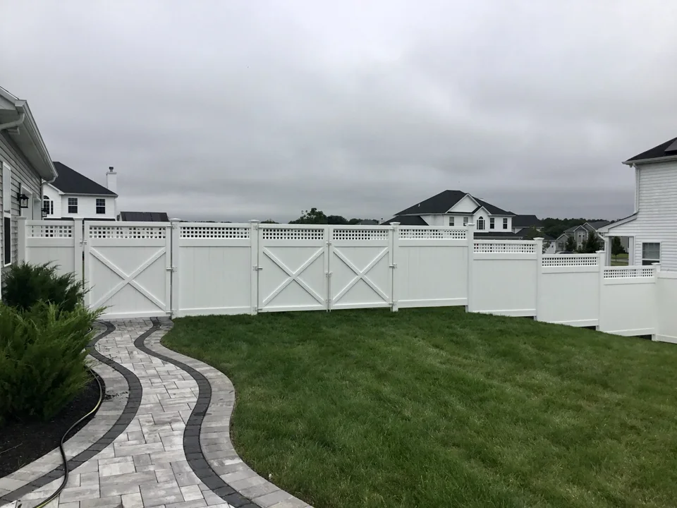 White PVC privacy fence with square lattice top and double-drive gates in Wading River, New York
